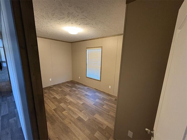 spare room with hardwood / wood-style floors and a textured ceiling