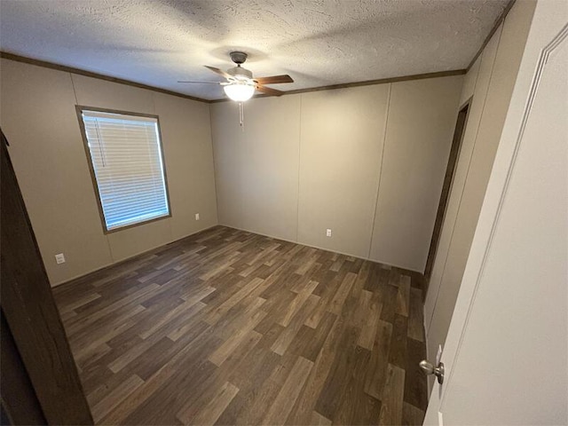 spare room with a textured ceiling, dark hardwood / wood-style floors, ceiling fan, and crown molding