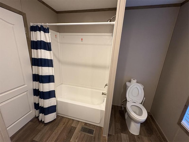 bathroom featuring hardwood / wood-style floors, toilet, crown molding, and shower / tub combo with curtain