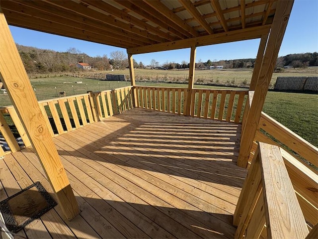 deck with a rural view and a yard