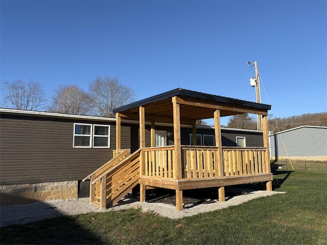 back of property with a wooden deck and a yard