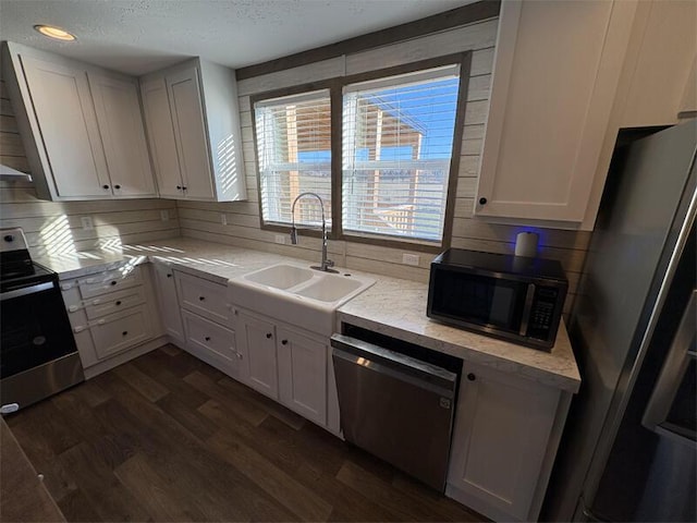 kitchen with sink, white cabinets, dark hardwood / wood-style floors, and appliances with stainless steel finishes