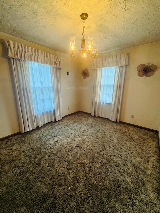 carpeted spare room with an inviting chandelier and a textured ceiling