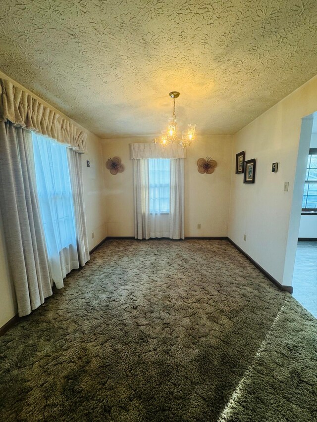 unfurnished dining area with dark carpet, a chandelier, and a textured ceiling