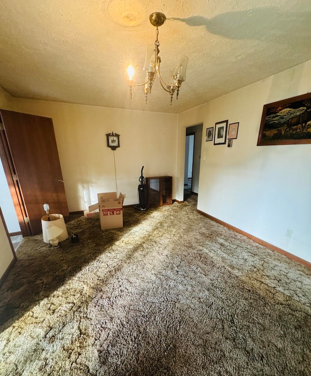 carpeted empty room with a textured ceiling and a notable chandelier