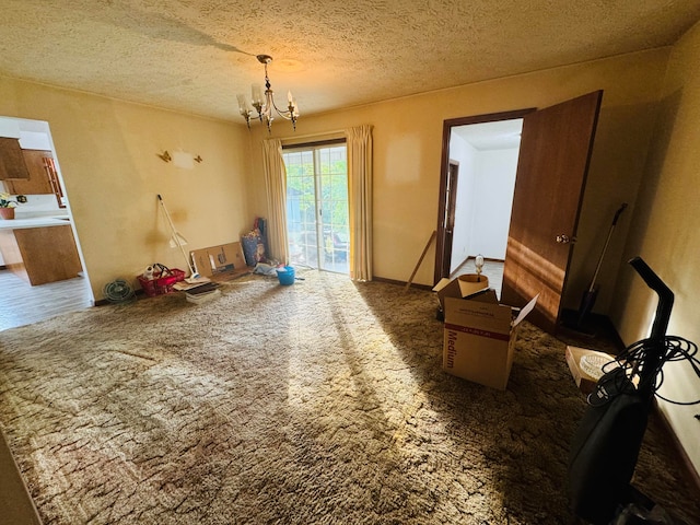 carpeted dining room featuring a textured ceiling and a chandelier