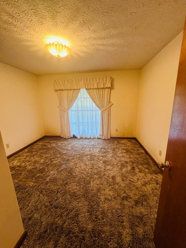 carpeted spare room with a textured ceiling