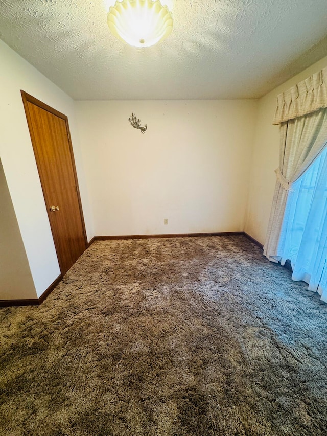 unfurnished bedroom featuring a textured ceiling, a closet, and dark colored carpet