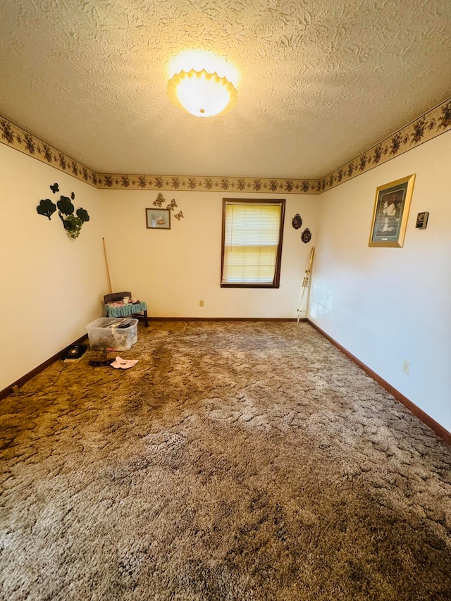 empty room with a textured ceiling and carpet floors