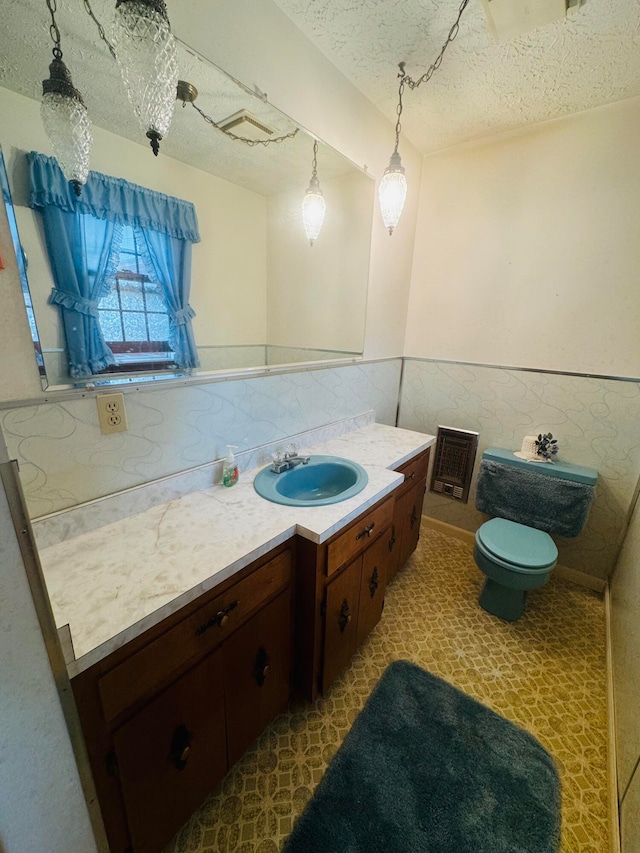 bathroom with a textured ceiling, vanity, and toilet