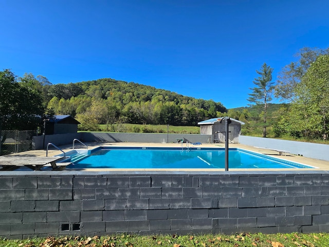 view of swimming pool featuring a diving board