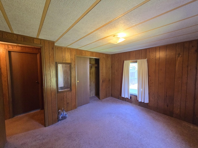 163 Eulett Ln, Vanceburg, KY 41179 - unfurnished bedroom with carpet flooring, wood walls, a closet, and a textured ceiling