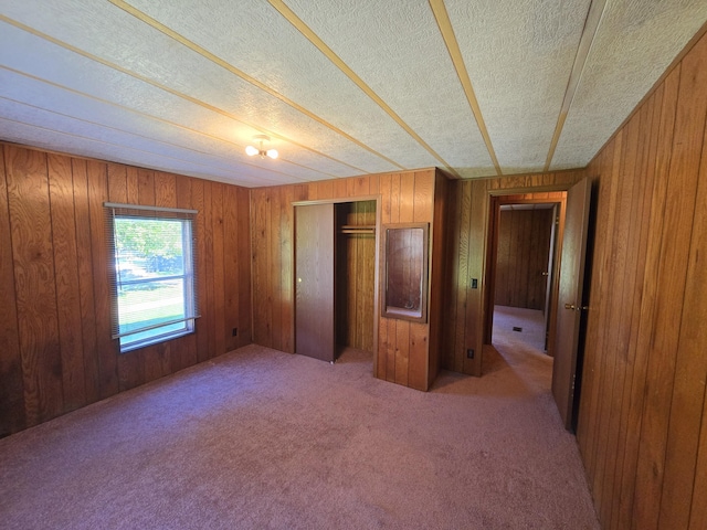 163 Eulett Ln, Vanceburg, KY 41179 - unfurnished bedroom featuring carpet floors, a textured ceiling, wood walls, and a closet