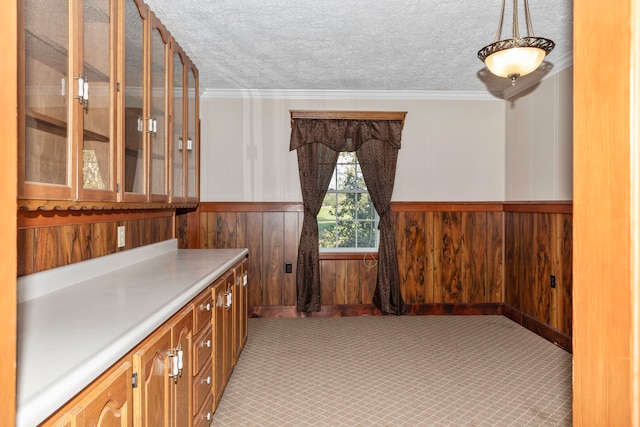 bar featuring light colored carpet, a textured ceiling, crown molding, and wood walls