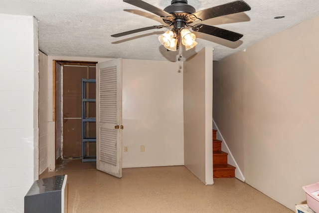 interior space featuring ceiling fan and a textured ceiling