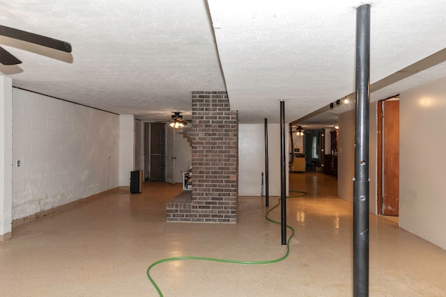 basement featuring ceiling fan and a textured ceiling