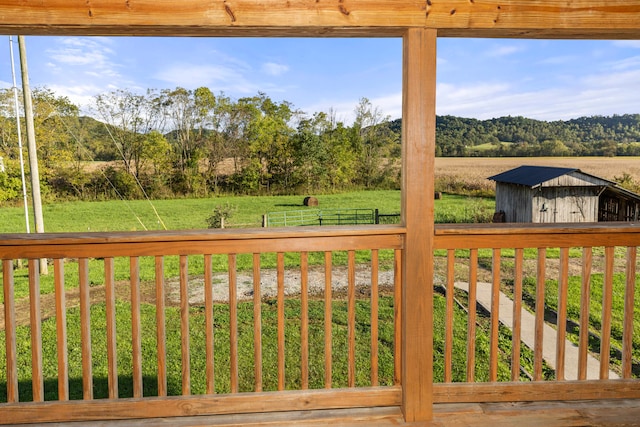 wooden terrace featuring a yard and a storage unit