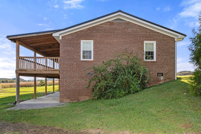 view of side of home with a deck, a yard, and a patio area