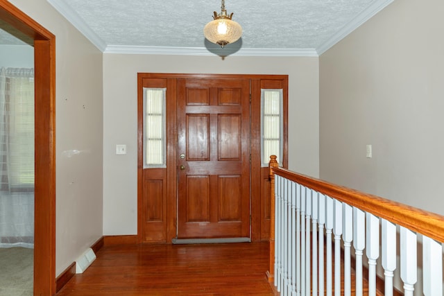 foyer featuring a textured ceiling, ornamental molding, and dark wood-type flooring