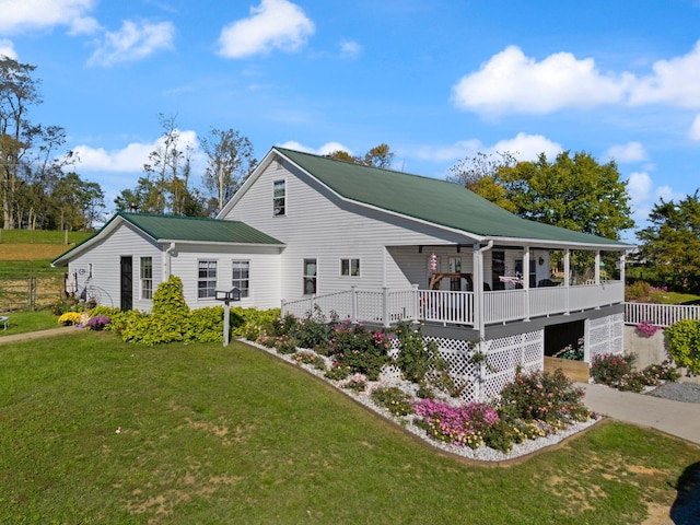 view of side of property with a yard and covered porch