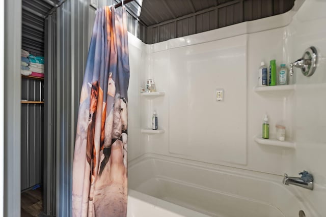 bathroom featuring hardwood / wood-style floors and shower / bathtub combination with curtain