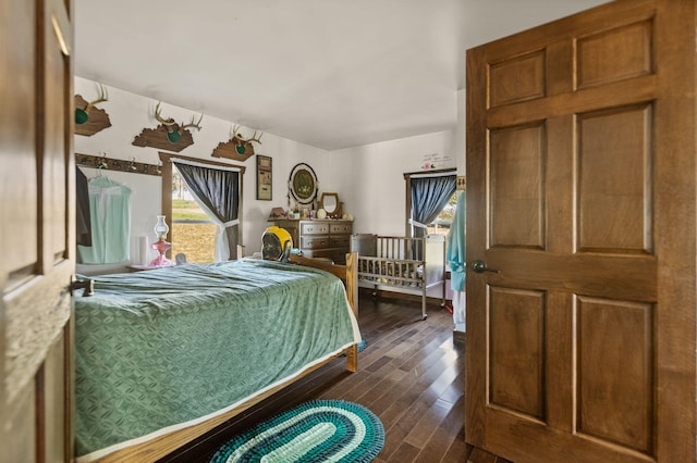 bedroom with dark hardwood / wood-style flooring