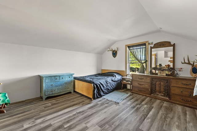 bedroom featuring dark wood-type flooring and lofted ceiling