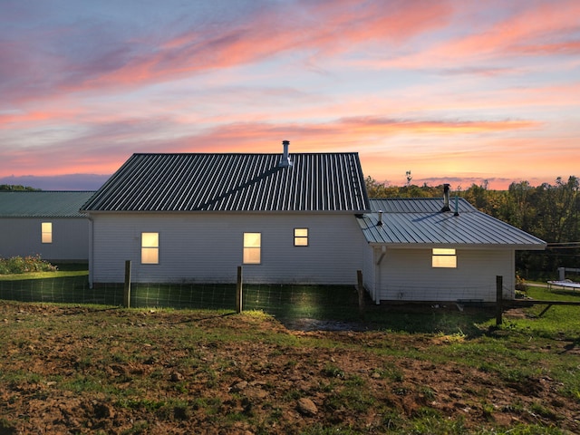 back house at dusk featuring a yard