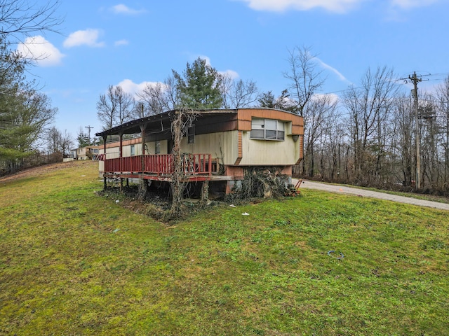 back of property with a wooden deck and a lawn