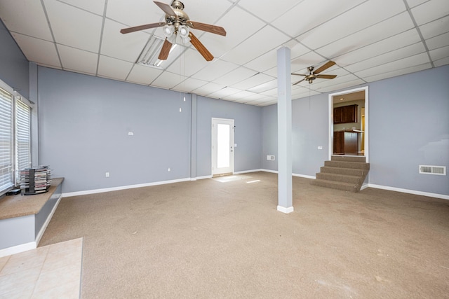 carpeted spare room featuring a drop ceiling and ceiling fan