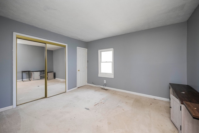 unfurnished bedroom featuring light carpet and a textured ceiling