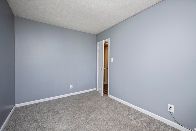 empty room with a textured ceiling and carpet