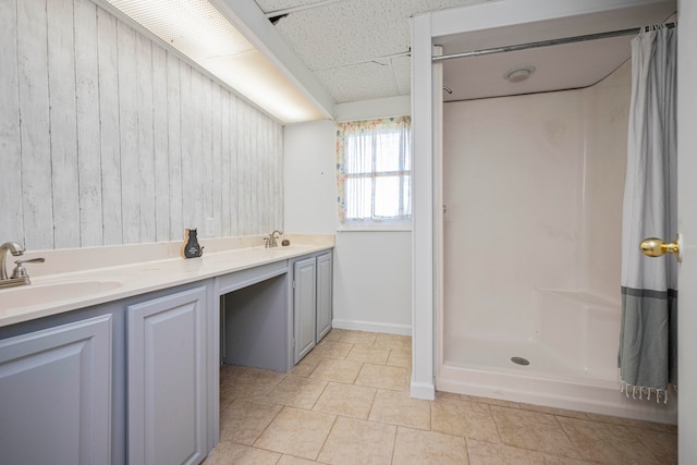 bathroom with vanity, wooden walls, tile patterned flooring, and a shower with shower curtain