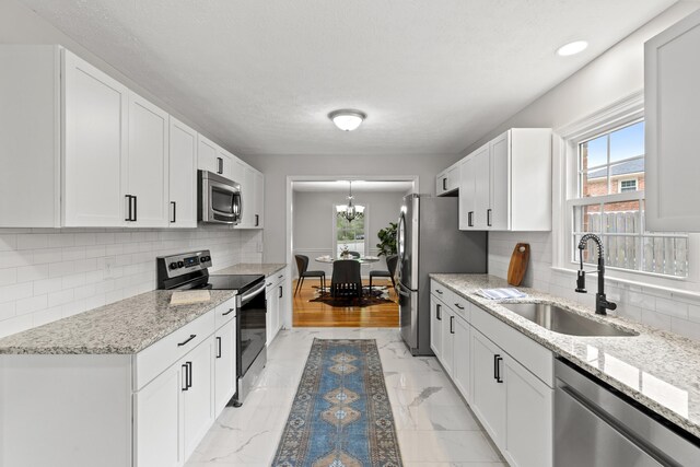 kitchen featuring stainless steel appliances, sink, and white cabinetry