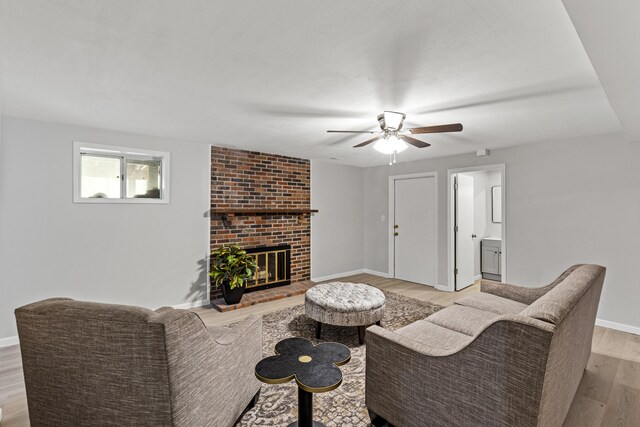 living room with ceiling fan, light hardwood / wood-style flooring, and a fireplace