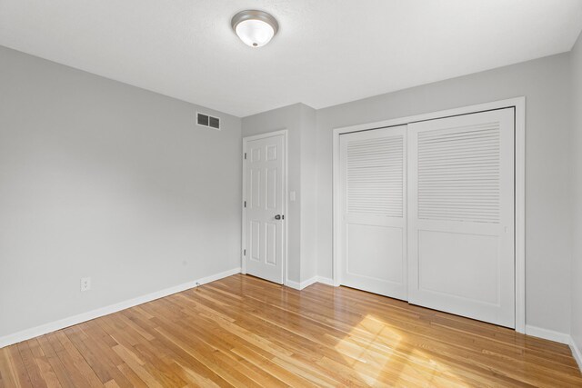 unfurnished bedroom featuring hardwood / wood-style floors and a closet