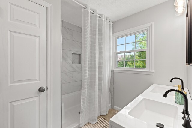 bathroom with a textured ceiling, vanity, and separate shower and tub