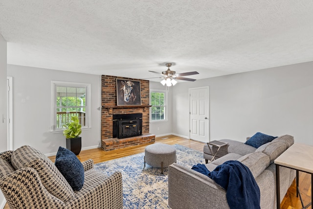 living room with light wood-type flooring, a wealth of natural light, and a textured ceiling