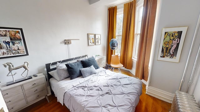 bedroom featuring radiator heating unit and dark hardwood / wood-style floors