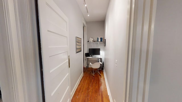 hallway featuring hardwood / wood-style floors and rail lighting