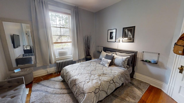 bedroom featuring radiator and hardwood / wood-style flooring