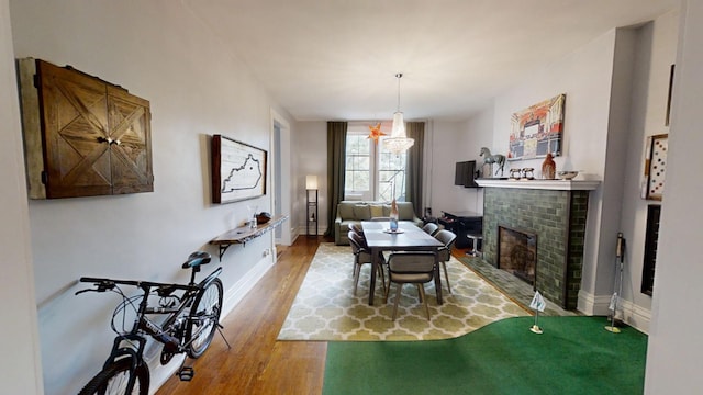 dining area with a brick fireplace and hardwood / wood-style flooring