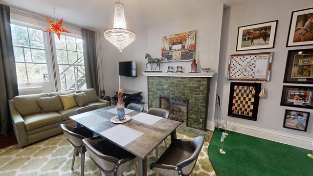 carpeted dining space with a chandelier and a fireplace