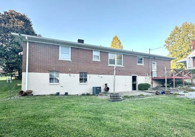 back of house with central AC unit, a lawn, and a deck