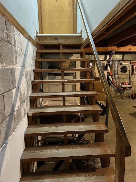 stairs featuring concrete flooring