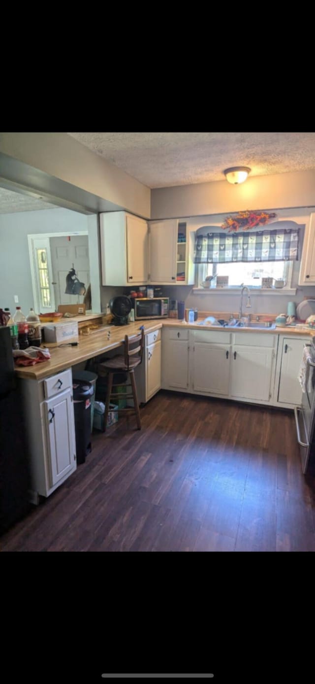 kitchen featuring dark wood-type flooring, white cabinetry, sink, and stainless steel appliances