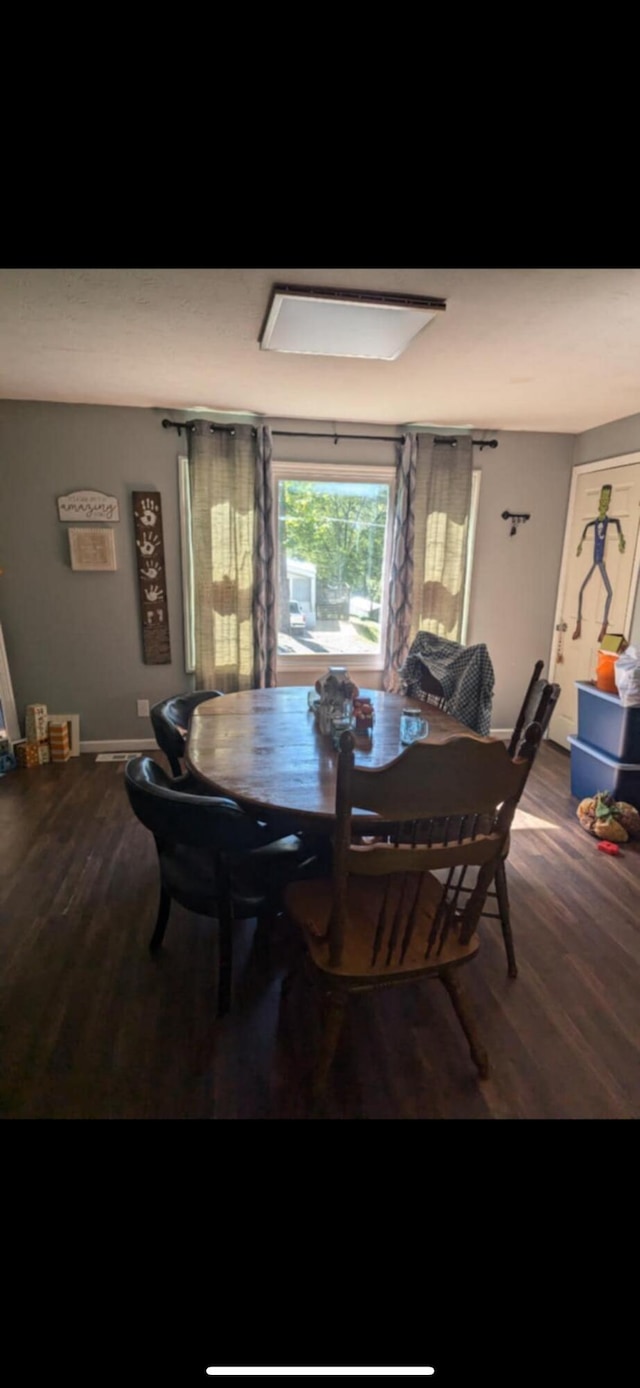 dining space with wood-type flooring