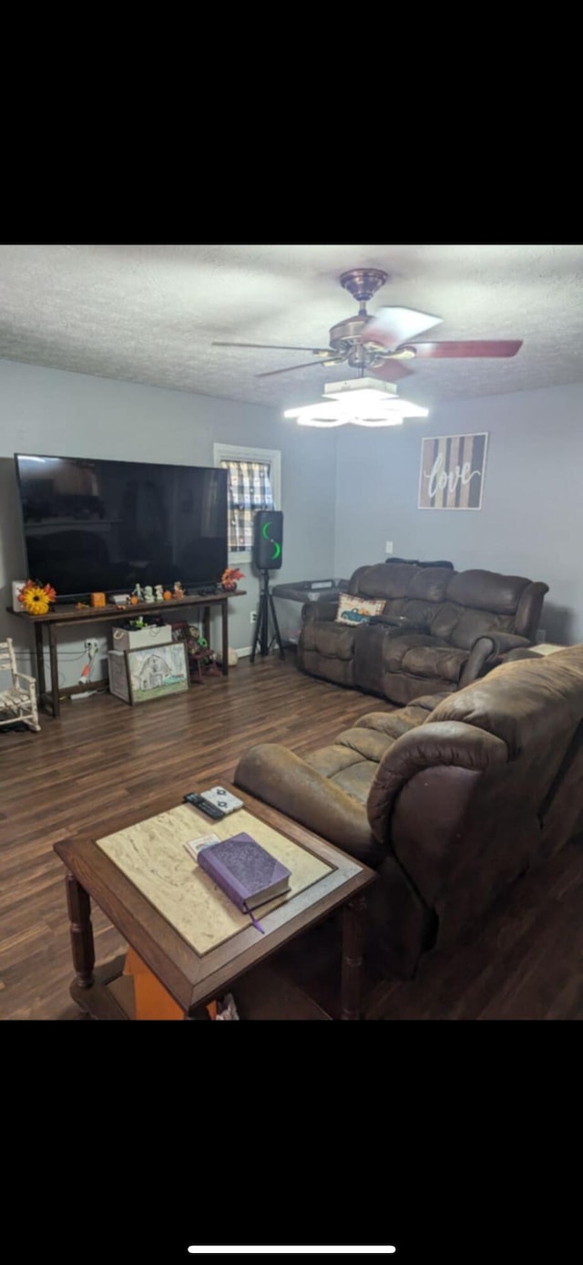 living room featuring wood-type flooring, ceiling fan, and a textured ceiling