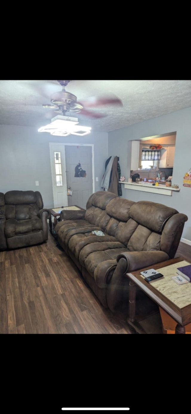 living room featuring a textured ceiling, hardwood / wood-style floors, and ceiling fan