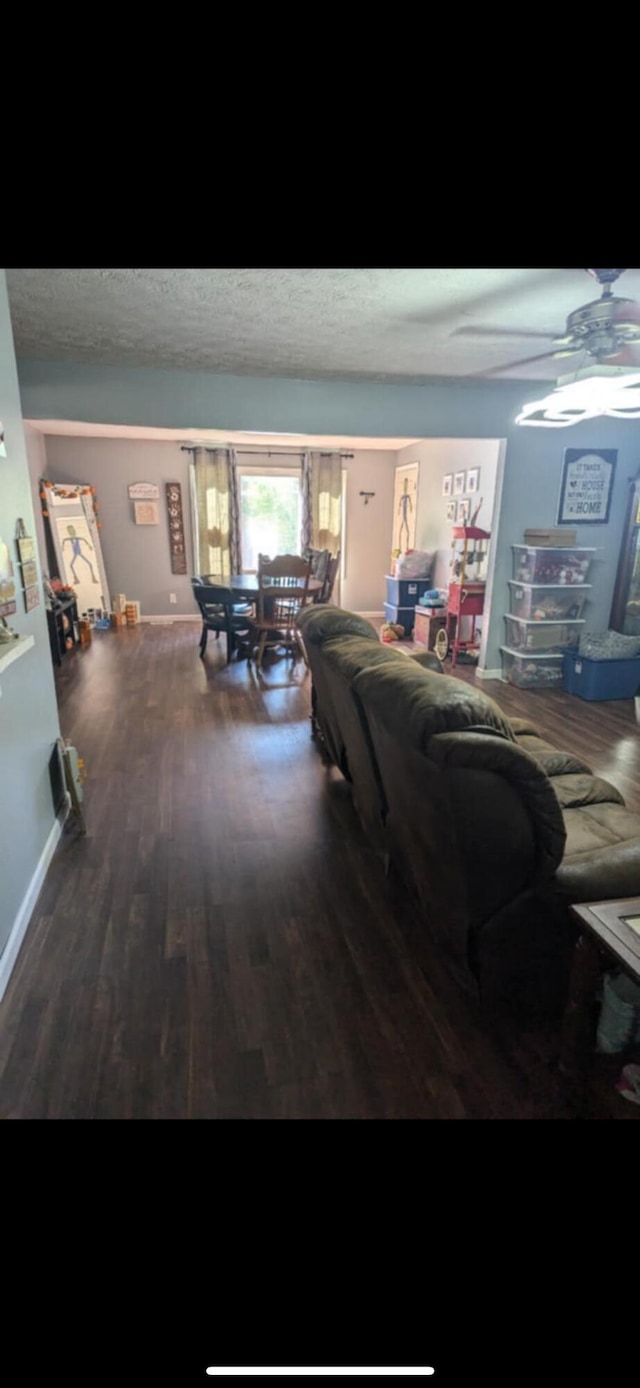 living room with a textured ceiling, hardwood / wood-style flooring, and ceiling fan